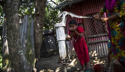 Una niña bebe de un pozo contaminado con arsénico en Totar Bagh, Bangladesh.