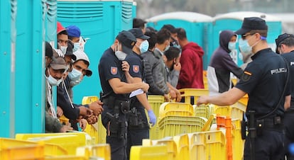 Varios inmigrantes aguardan  en el muelle de Arguineguín (Gran Canaria).