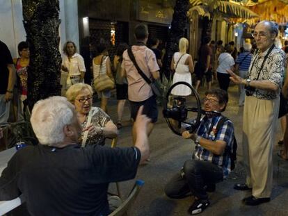 El artista plástico Antoni Miralda (derecha) conversa con vecinos de Gràcia durante el rodaje.