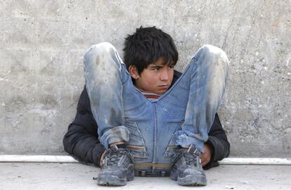 Un niño refugiado sirio espera sentado en el suelo junto a un acceso fronterizo en la ciudad de Kilis (Turquía).