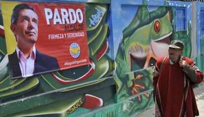 Transeunte passa por cartaz do candidato Rafael Pardo, em Bogotá.