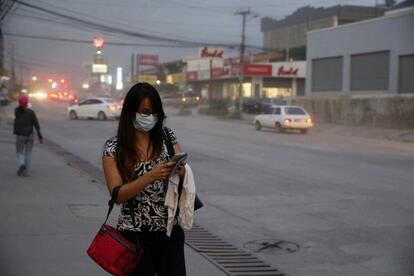 Una mujer usa un tapabocas para evitar respirar la ceniza que cae en la ciudad de San José (Costa Rica).