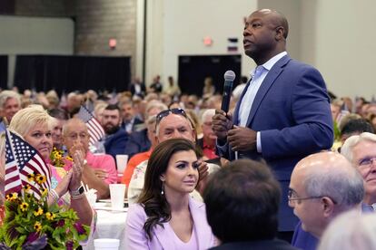 Republican presidential candidate Sen. Tim Scott, R-S.C., right, walks by Casey DeSantis