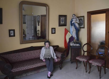 María Luz Luis Illada, en su casa de Tenerife, con el retrato de sus familiares y la talla de la virgen.