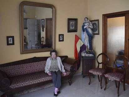 María Luz Luis Illada, en su casa de Tenerife, con el retrato de sus familiares y la talla de la virgen.