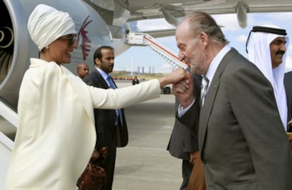 El Rey don Juan Carlos saluda a Mozah Bint Nasser, esposa del emir de Catar, Hamad Bin Jalifa al-Thani (a la derecha de la imagen), a su llegada al aeropuerto de Barajas.