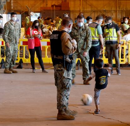 Unos militares juegan a la pelota con uno de los niños afganos llegado en el vuelo de este martes
