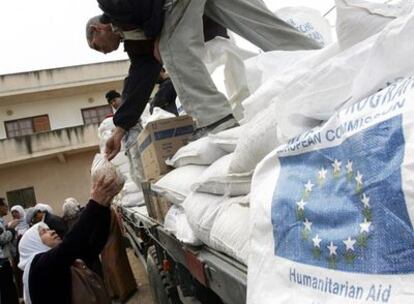 Una mujer palestina recibe un lote de comida de la Unión Europea a través del programa mundial de alimentos de la ONU.