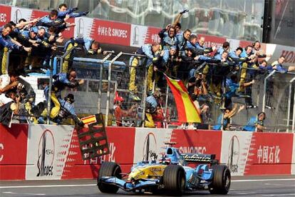 Fernando Alonso cruza la meta como ganador ante el alborozo de su equipo y señalando con los dedos los siete triunfos.