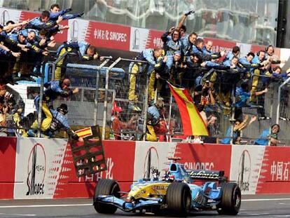 Fernando Alonso cruza la meta como ganador ante el alborozo de su equipo y señalando con los dedos los siete triunfos.