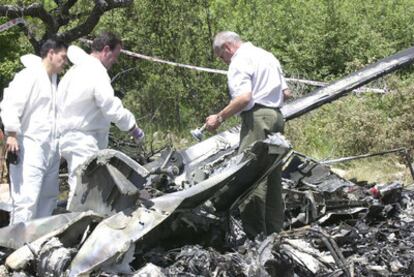 Dos operarios revisando el helicóptero tras el accidente.