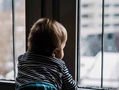 Un niño mira por la ventana.