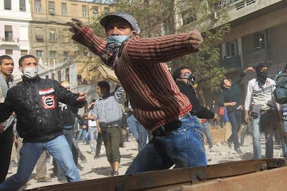 Un manifestante lanza una piedra contra la policía que protege el ministerio del Interior en El Cairo.