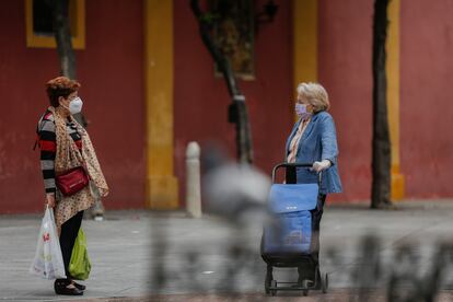 Dos personas conversan a distancia durante el quinto de la Fase 1 del plan de desescalada en Sevilla.