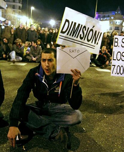 Un joven sentado en la calle Génova en protesta por los posibles sobresueldos en el Partido Popular.