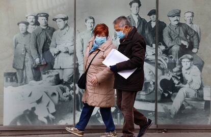 Una pareja pasea con mascarilla por una calle de Sabadell (Barcelona).