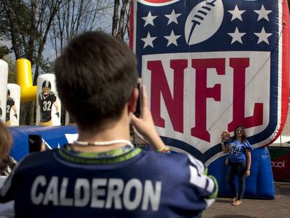 Fanáticos mexicanos se toman una foto frente al logo de la NFL.