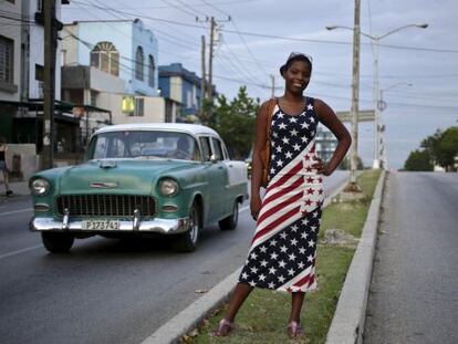 Jovem cubana vestida com a bandeira norte-americana em Havana.