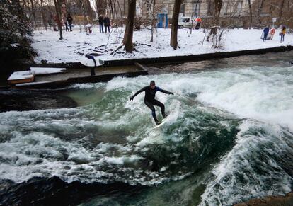 Una persona practica surf en el canal de Eisbach, a su paso por Múnich (Alemania).