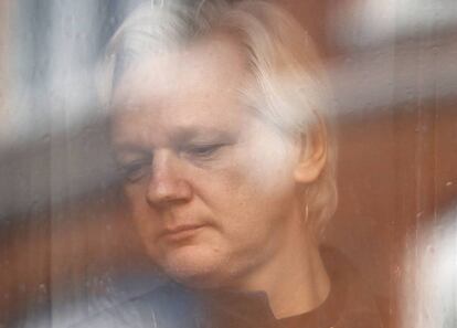 Jullian Assange mira a través de la ventana de la embajada de Ecuador en una imagen tomada el 19 de mayo de 2017.