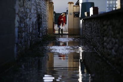 Una mujer limpia el suelo de su casa después de que el río Sena se desbordara en Cléon (Francia).