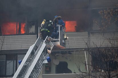 Un bombero rescata a una persona de su vivienda, alcanzada por un proyectil ruso, este martes en Kiev.