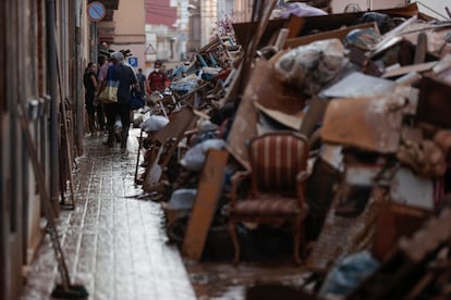 Voluntarios y vecinos trabajan para despejar una calle de Paterna (Valencia), este martes.