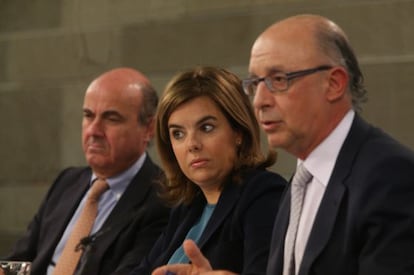 Economy Minister Luis de Guindos, Deputy PM Soraya Sáenz de Santamaría and Finance Minister Cristóbal Montoro speak to the press on Friday.