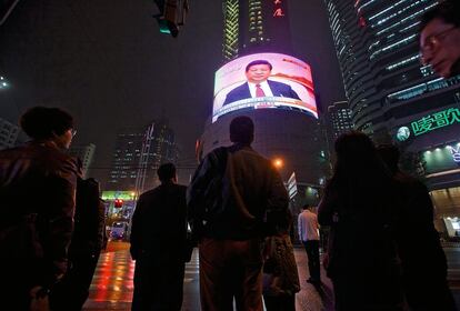 Los paseantes observan en las calles de Shanghái las noticias del Congreso del Partido Comunista celebrado el 16 de octubre en Pekín. 
