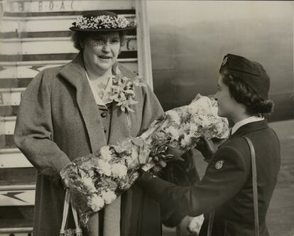 La soprano noruega Kirsten Flagstad recibe un ramo de flores de manos de una azafata cuando llega en avión para cantar en Londres, el 16 de abril de 1952.