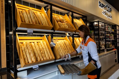 Una empleada repone pan en una gasolinera Repsol.