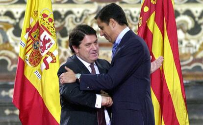 El expresidente del Gobierno valenciano José Luis Olivas (izquierda) abraza a su antecesor, Eduardo Zaplana, tras entegarle la Alta Distinción de la Generalitat, en Valencia en 2002.