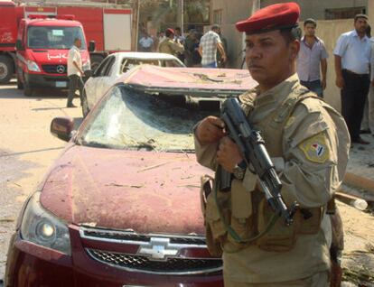 Un soldado iraquí vigila la zona donde ha explotado uno de los coches bomba.