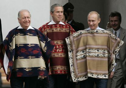 Cumbre de la APEC (Foro de Cooperación Económica Asia-Pacífico), en el palacio de La Moneda, en Santiago de Chile. En la foto, Ricardo Lagos (i), presidente de Chile; George W. Bush (c), presidente de Estados Unidos y Vladimir Putin, presidente de Rusia, se preparan para la foto de familia vestidos con un tradicional poncho andino, el 21 de noviembre de 2004.