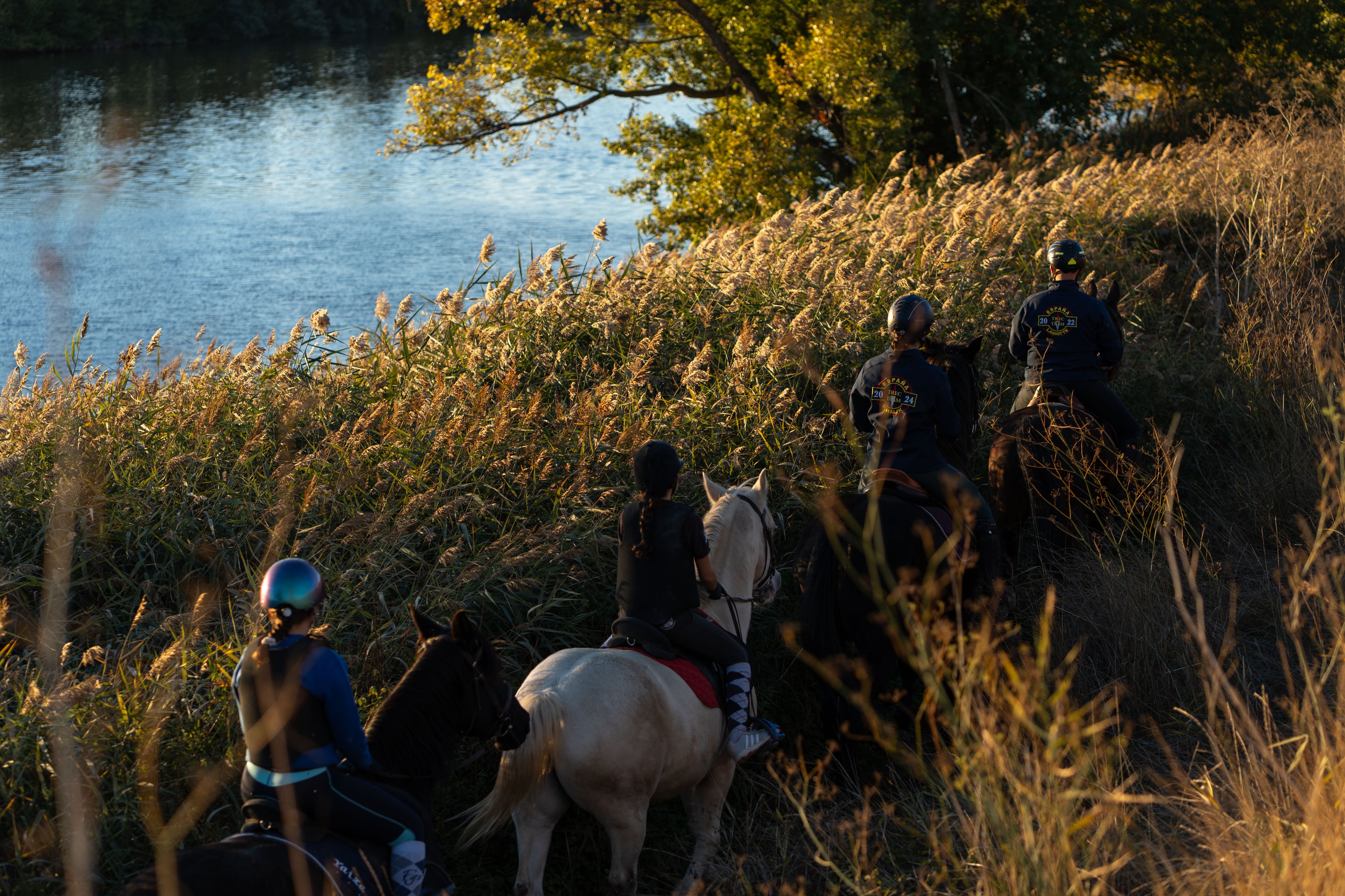 Aficionados a montar a caballo se aproximan al embarcadero de Tordesillas por la senda del Duero a la caída del sol.