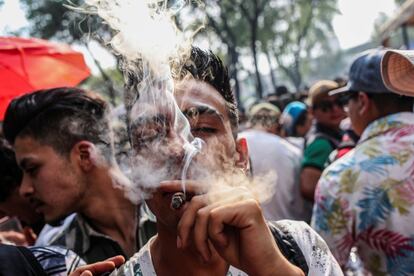 Un hombre fuma marihuana fuera del edificio del Senado de México durante una manifestación para conmemorar la fiesta informal del cannabis.