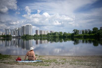 Una mujer sentada a orillas del río Dniéper, en Kiev, Ucrania, mientras las temperaturas del verano comienzan a subir. El domingo, dos puntos de la capital de Ucrania fueron atacados con misiles. La ciudad llevaba semanas en calma.