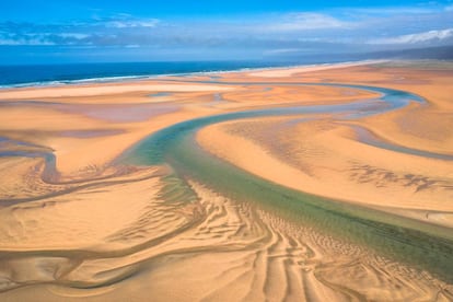 Fotografía aérea realizada con un dron de la playa islandesa de Rauðisandur, con arroyos de agua azul y arena amarilla.