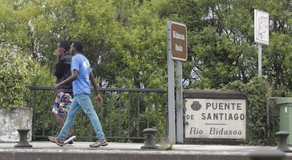 Dos migrantes intentan este jueves cruzar el puente sobre el río Bidasoa que separa España de Francia.