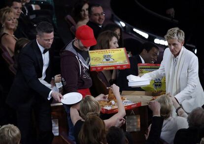 La presentadora de la gala, Ellen DeGeneres, reparte pizza y platos de papel durante la 86 edición de los premios Oscar