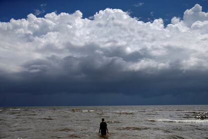 Jordan Carambat se adentra en el océano cuando la tormenta tropical Gordon se acerca a Waveland, Misisipi.