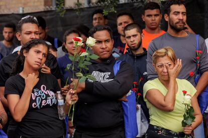 Migrants hold flowers and listen to speakers during a vigil for the eight migrants that were killed while waiting at a bus stop, in Brownsville, Texas, on May 8, 2023.