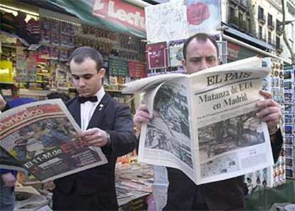 Dos empleados ojean ediciones especiales de los periódicos en un quiosco de las Ramblas de Barcelona ayer por la tarde.