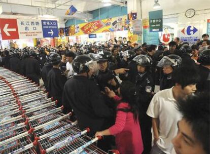 Numerosos policías tratan de contener a los manifestantes en un centro Carrefour en Hefei.