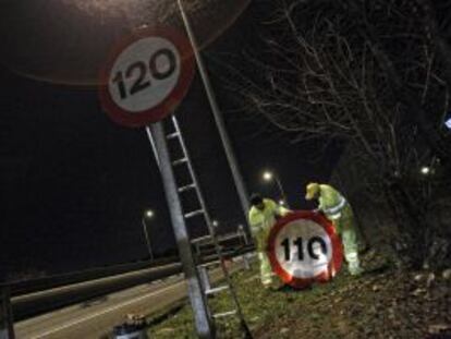 Dos operarios cambian los límites de velocidad en una autopista, en marzo pasado.