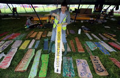 Trabajadores del festival británico de Glastonbury colorean carteles que se pondrán por todo el recinto, 20 de junio de 2013.