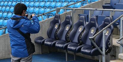 Un aficionado de Manchester City fotografía el banquillo visitante en el estadio Etihad.