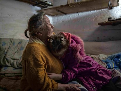 Khrystyna hugs her grandmother Liubov as they take cover at the basement of their house during the shelling in Bohoyavlenka, Ukraine, on Sunday, April 9, 2023.