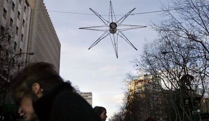 Viandantes cruzan bajo una de las estrellas luminosas, colocada en la calle de la Princesa.