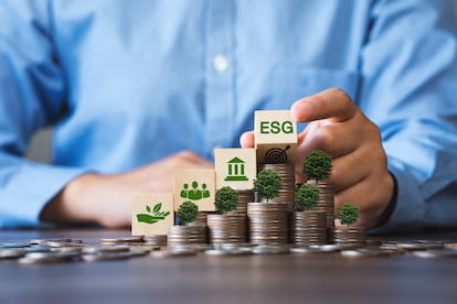 ESG Concepts in Environment, Society and Governance Invest in green finance Sustainable organizational development Businessman holding a flipping wooden block On the coin a tree grows.